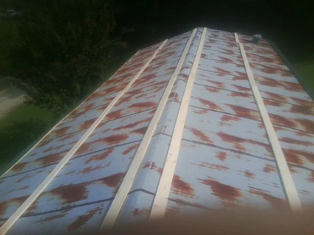 Rusted metal roof panels with new wood purlins before replacement — Storm Damage Roof Repair in Ocala by Roofing Brothers