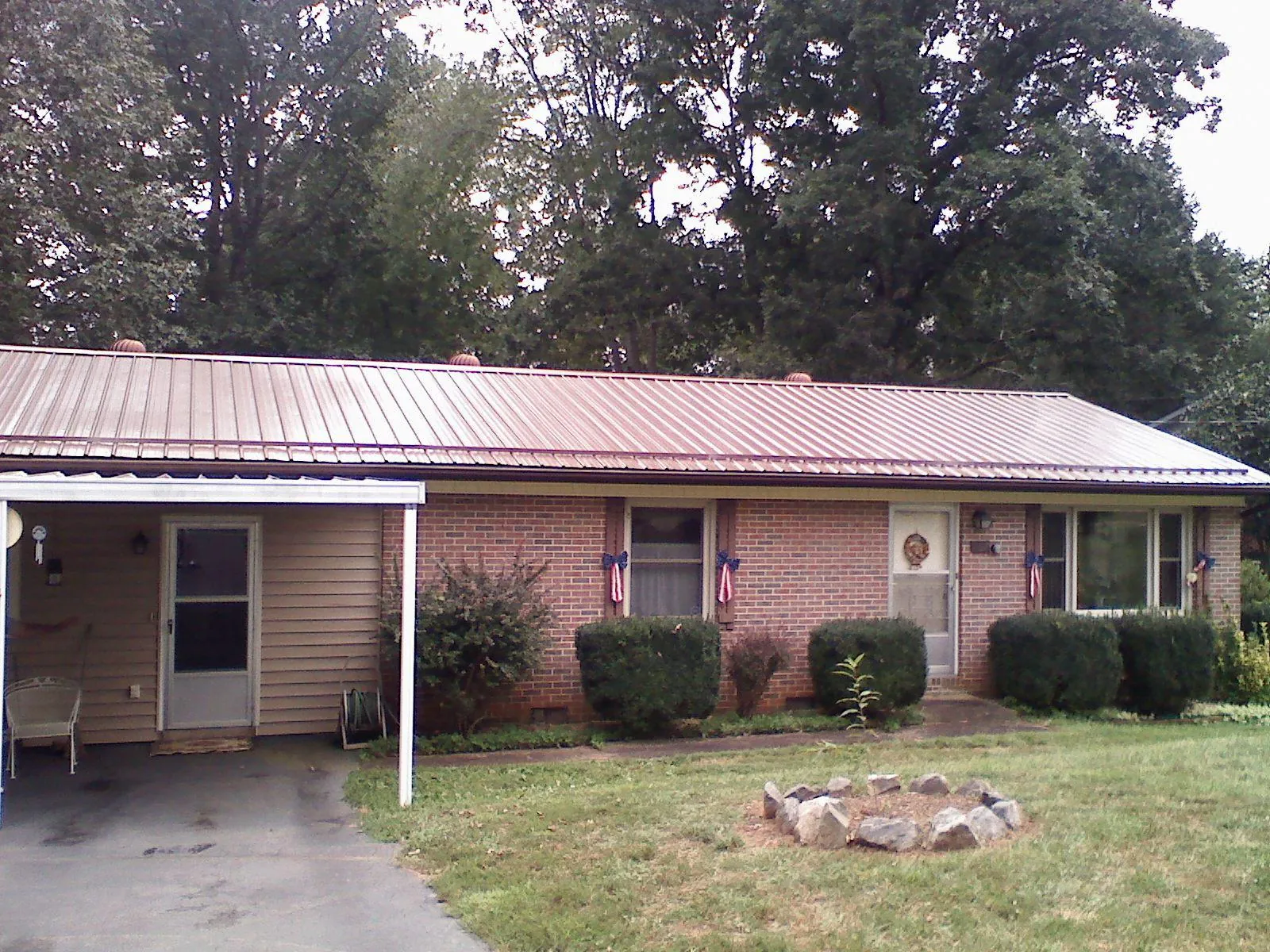 Bronze metal roof and carport on a brick ranch home — Roof Repair work by our crew in Ocala